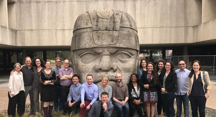 conference participants posing with an Olmec head.